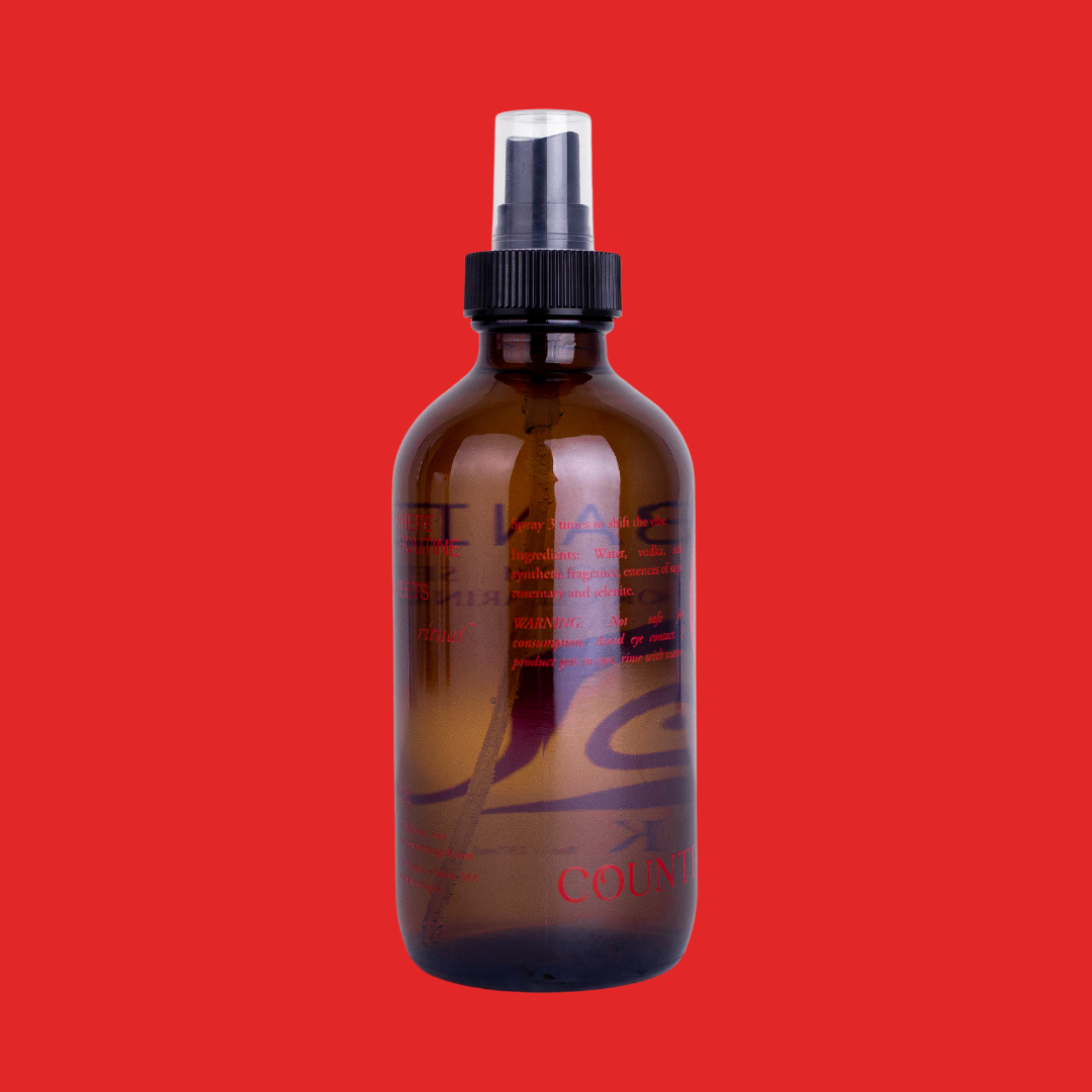 Back of Banish's amber glass bottle, showing red text that reads "Where routine meets ritual. Spray 3 times to shift the vibe. Ingredients: Water, vodka, safe synthetic fragrance, essences of sage, rosemary, and selenite. Warning: Not safe for consumption. Avoid eye contact. If product gets in eyes, rinse with water. For full ritual, visit www.countermagick.com. Coven made- Salem, MA. @countermagick"
