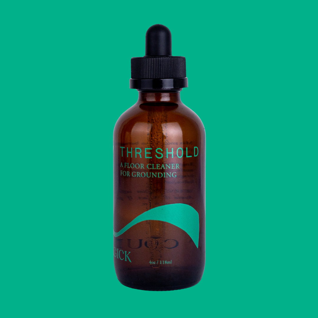 Threshold: A Floor Cleaner for Grounding in an amber glass bottle intentionally adorned with a minimalist green wave. 4 oz/118 mL